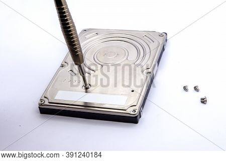 Opening Of Hard Disk For Data Recovery Isolated On White Background. Dismantled Hard Drive. Screwdri