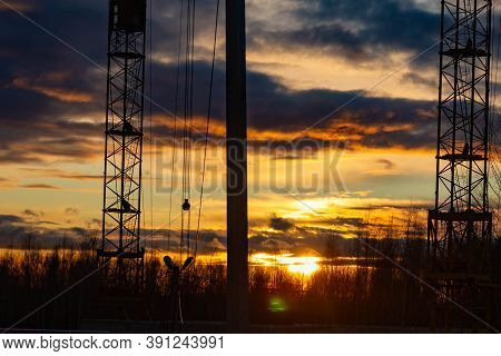 Cranes On The Background Of The Sunset. House Construction.