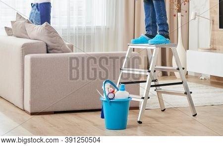 Cropped View Of Man Climbing Ladder To Clean Ceiling. Cleaning Service Concept