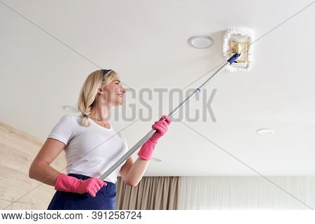 Maid Woman Holding Mop Pile, Cleaning Ceiling In Living Room. House Cleaning Service Concept.