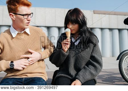 Grumpy Couple Sitting On The Stairs Outdoors, Eating Ice Cream