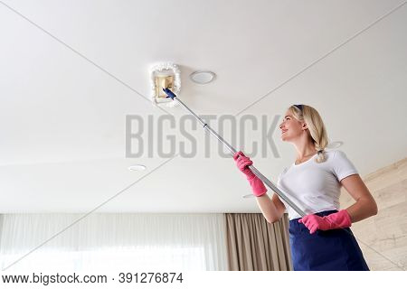 Maid Woman Holding Mop Pile, Cleaning Ceiling In Living Room. House Cleaning Service Concept.