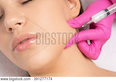 Cosmetologist Makes Lipolytic Injections To Burn Fat On The Chin, Cheeks And Neck Of A Woman Against