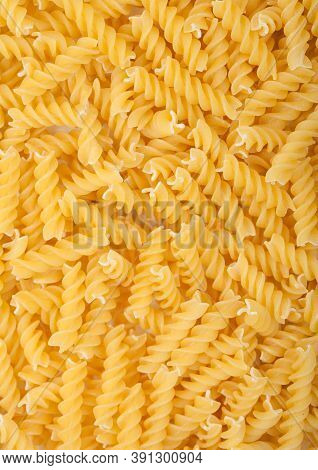 Raw Homemade Yellow Fusilli Pasta As Texture Background. Top View