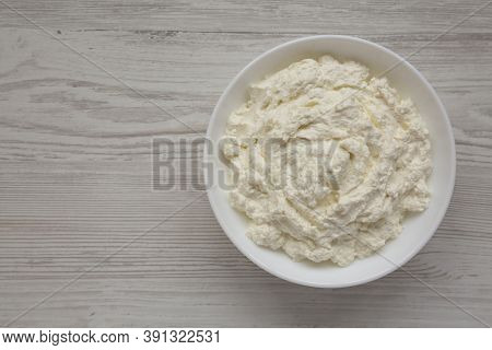 Tasty Ricotta Cheese In A White Bowl, Top View. Overhead, From Above, Flat Lay. Copy Space.