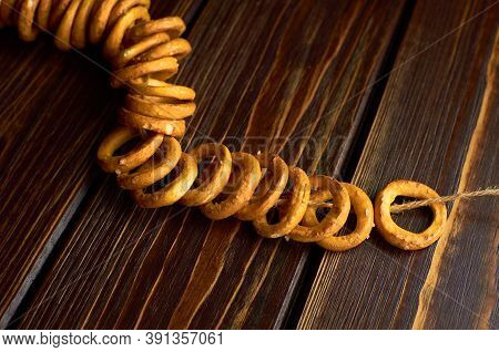 Traditional Russian Wheat Bagels On A Rope On Dark Wooden Table.
