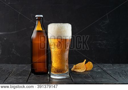 Freshly Poured Beer And Potato Chips. Beer And Snack. The Bright Light Of The Beer. High Beer Foam.