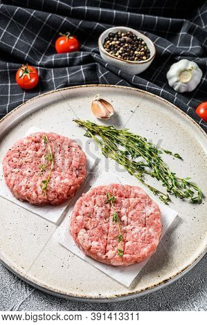 Raw Pork Patty, Ground Meat Cutlets On A Cutting Board. Organic Mince. Gray Background. Top View