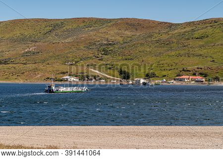 Punta Arenas, Chile - December 12, 2008: Green-white Ferry Crosses Blue Water Otway Sound To Its Lan