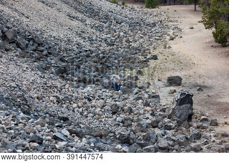 Newberry National Monument, Oregon / Usa - August 17, 2014:  An Older Man Looks At Rocks On The Edge