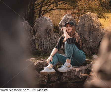 Zoomed Full Body Portrait Of An Attractive Brunette Sitting On A Well At The Rajcica Wells Natural L