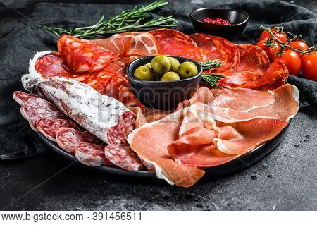 Cured Meat Platter Of Traditional Spanish Tapas. Chorizo, Jamon Serrano, Lomo And Fuet. Black Backgr