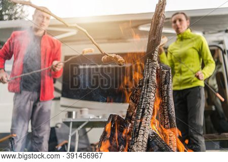 Camping Theme. Caucasian Friends In His 40s And The Campfire Time. Making Some Food On The Fire. Out