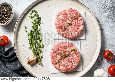 Raw Pork Patty, Ground Meat Cutlets On A Cutting Board. Organic Mince. Gray Background. Top View