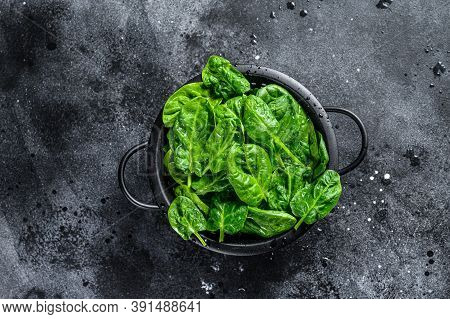 Fresh Spinach Leaves In A Colander. Black Background. Top View
