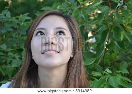 Beautiful young asian woman thinking in the park