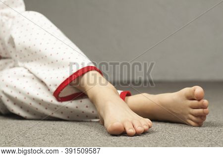 Legs Of A Child 8-10 Years Old In Pajamas. Foot