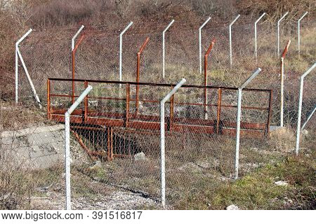 Heavy Duty Industrial Old Rusted Metal Bridge Over Water Canal Fenced Off With Protective Wire Fence