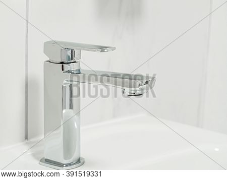 New Metal Shiny Valve Square Sink Faucet With Feflections In White Interior. Close-up. Macro