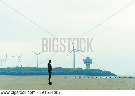 LIVERPOOL, UK - FEB 23, 2020: Antony Gormley's Another Place artwork on beach in England in United Kingdom