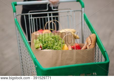 Groceries From A Supermarket In A Trolley Outdoors. Food Delivery During Quarantine. Cruft Paper Eco