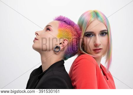 Young Lesbian Woman Couple With Vivd Colored Short Hair And Jackets Posing On White Background. Pier