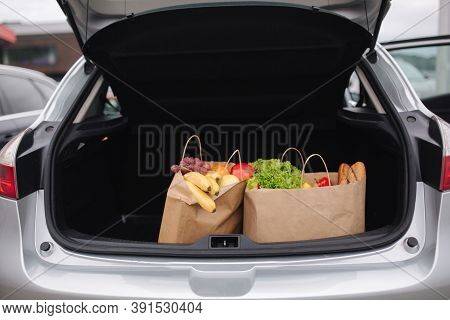 Groceries From A Supermarket In A Car Trunk. Food Delivery During Quarantine. Cruft Paper Eco Bags F