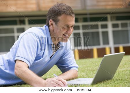 Uomo utilizzando computer portatile fuori scuola