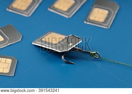 Fishing Triple Hook Caught On A Sim Card, Identity Theft Or Internet Fraud. Blue Background Gray Car