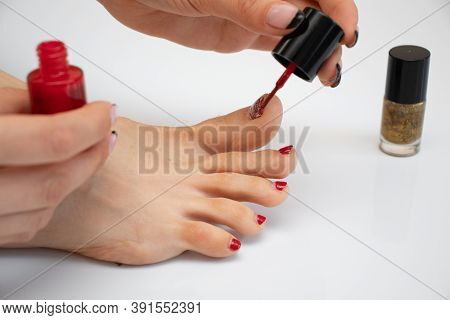 Girl Makes A Pedicure. Girl Paints Her Toenails. Woman Makes New Pedicure.the Process Of Applying Pe