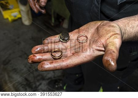 The Car Mechanic Holds In His Open, Dirty Hand A Bolt For Attaching The Engine Oil Sump Drain And An
