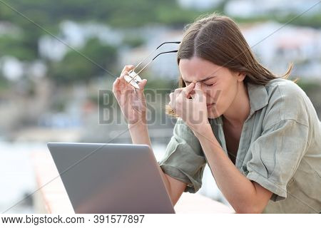 Stressed Woman Using Laptop Suffering Eyestrain Complaining Outdoors In A Balcony