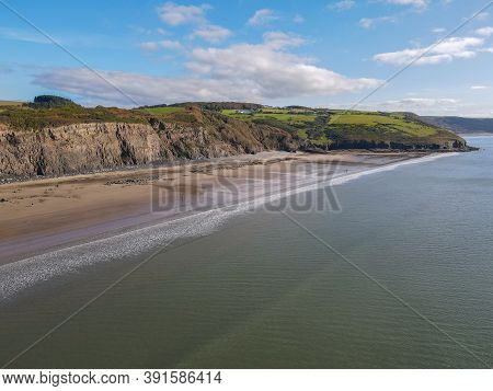 Tall Crumbling Cliffs Overlooking The Sandy Telpyn Beach And Light Blue Sea At Amroth, Pembrokeshire