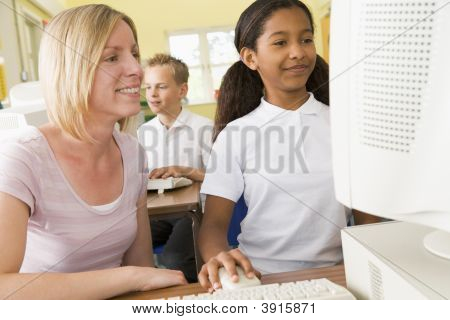 Insegnante aiutare allievi sui computer della scuola