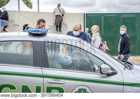 A Man Arguing With Policeman Regarding His Ticket To Formula 1 Championship In Portugal