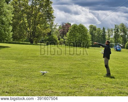 Jumieges, France - June Circa, 2019. Mature Male Technicians Outdoor, On Grass, Using Professional D