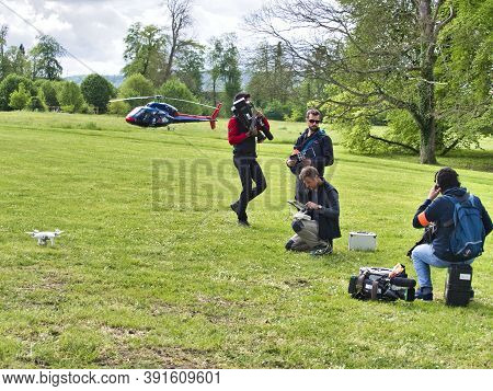 Jumieges, France - June Circa, 2019. Mature Male Technicians Outdoor, On Grass, Using Professional D