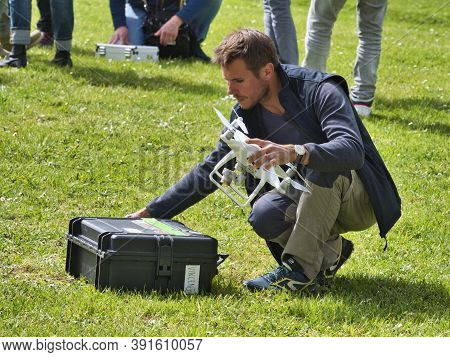 Jumieges, France - June Circa, 2019. Mature Male Technicians Outdoor, On Grass, Using Professional D