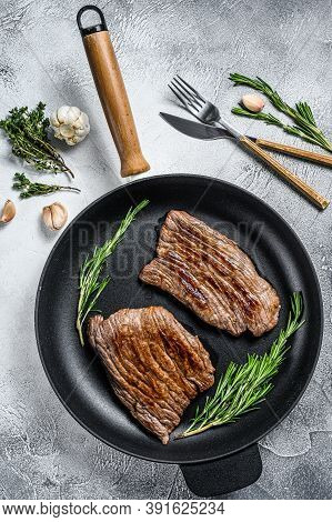 Grilled Flat Iron And Flank Steaks In A Pan. Marble Beef Meat. Gray Background. Top View