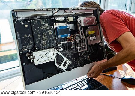 Male Computer Technician Repairing Broken Silver Desktop Computer While Opening Its Parts And Analys