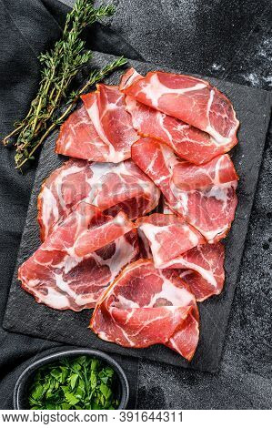 Italian Rolled Bacon Pancetta Piacentina. Pork Meat. Black Background. Top View