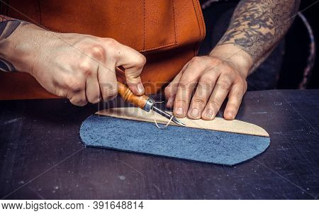 Artisan Performing Leatherwork On A New Product Piece