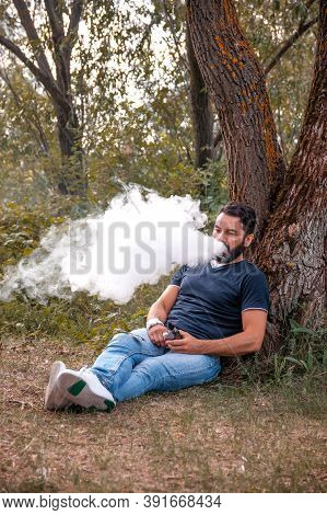 Modern Smoker Blowing A Lot Of Smoke Using Vape Electronic Cigarette. Vaping.
