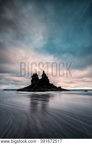 Rock In The Middle Of The Sea Where You Can See A Sky With Clouds And Waves