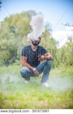 Stylish Brutal Smoker Enjoying An Electronic Cigarette In The Daylight. Hybrid Cigarette.