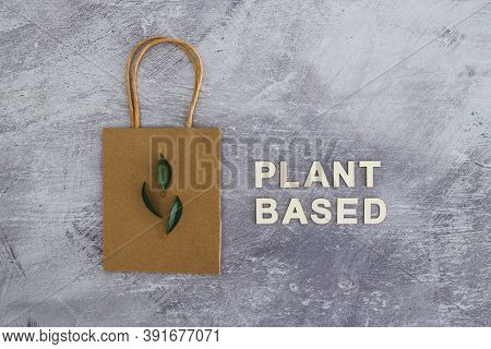 Sustainable Consumer Choices, Plant-based Text With Shopping Bag And Leaves On Concrete Background