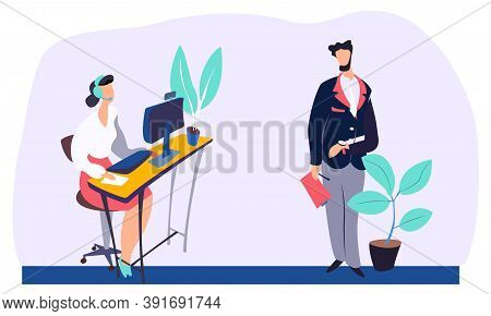 Woman With Headphones Is Working At A Computer Sitting At A Desk. A Man Standing Next To A Potted Fl