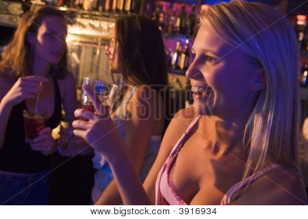 Ung kvinde i en Bar med venner