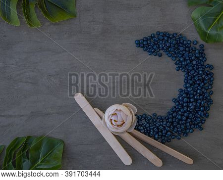 Wax Film For Depilation With Azulene Granules In The Shape Of A Heart On A Gray Background.