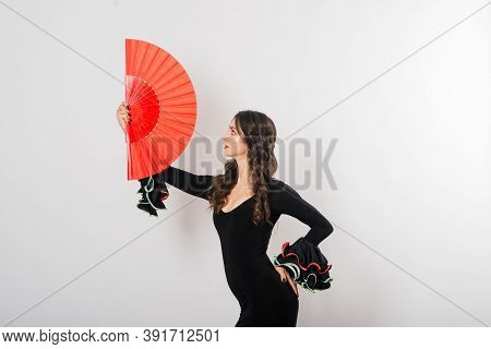 Portrait Of Beautiful Young Woman Dancing Flamenco In Studio